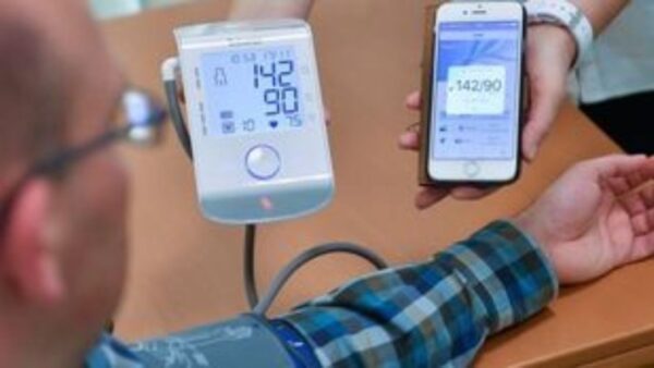 a person holding a device to measure blood pressure