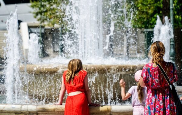 a group of people standing in front of a fountain