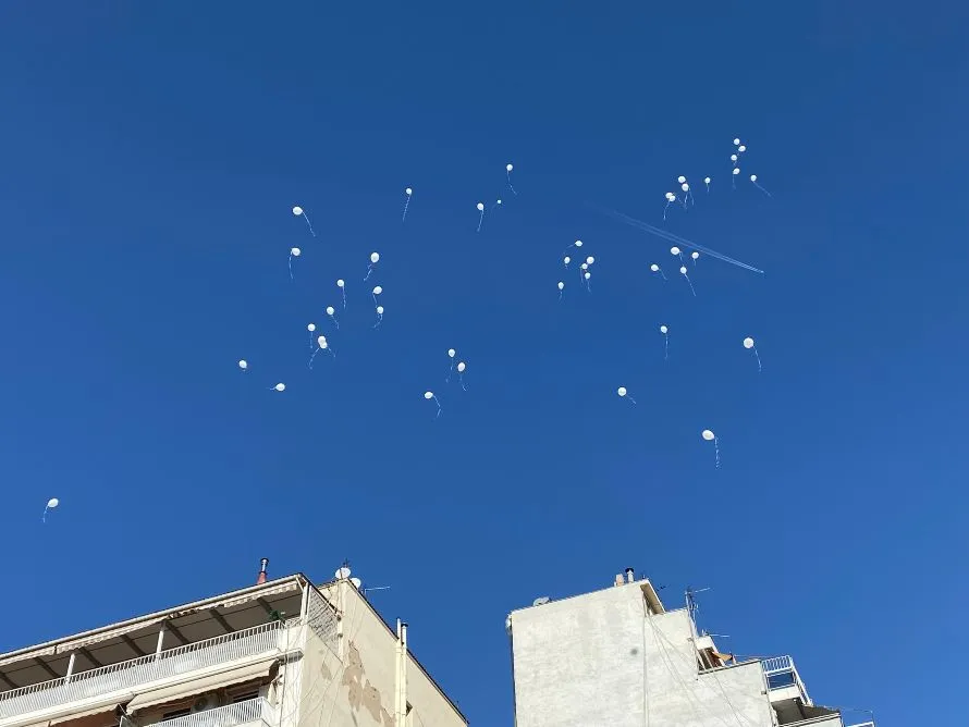 Λευκά μπαλόνια στον ουρανό της πόλης, ως φόρος τιμής στα θύματα τροχαίων